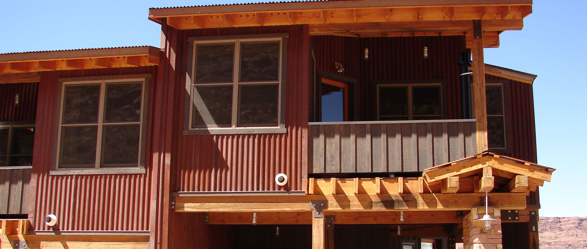 Front of view of townhouse entryways to Units #21 and #22 at Moab Springs Ranch, featuring two-car garages, covered decks and large woodframed windows.