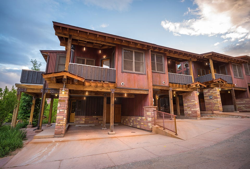 A row of townhouse units at Moab Springs Ranch features two-car garages built with brick and wood columns, covered balconies and large square woodframed windows.