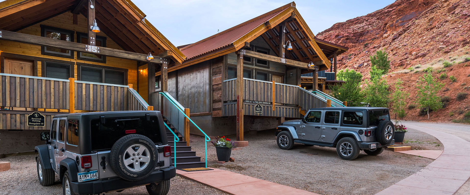 A large view of a small road winding through the lit driveways of yellow and beige painted townhouse units of Moab Springs Ranch.