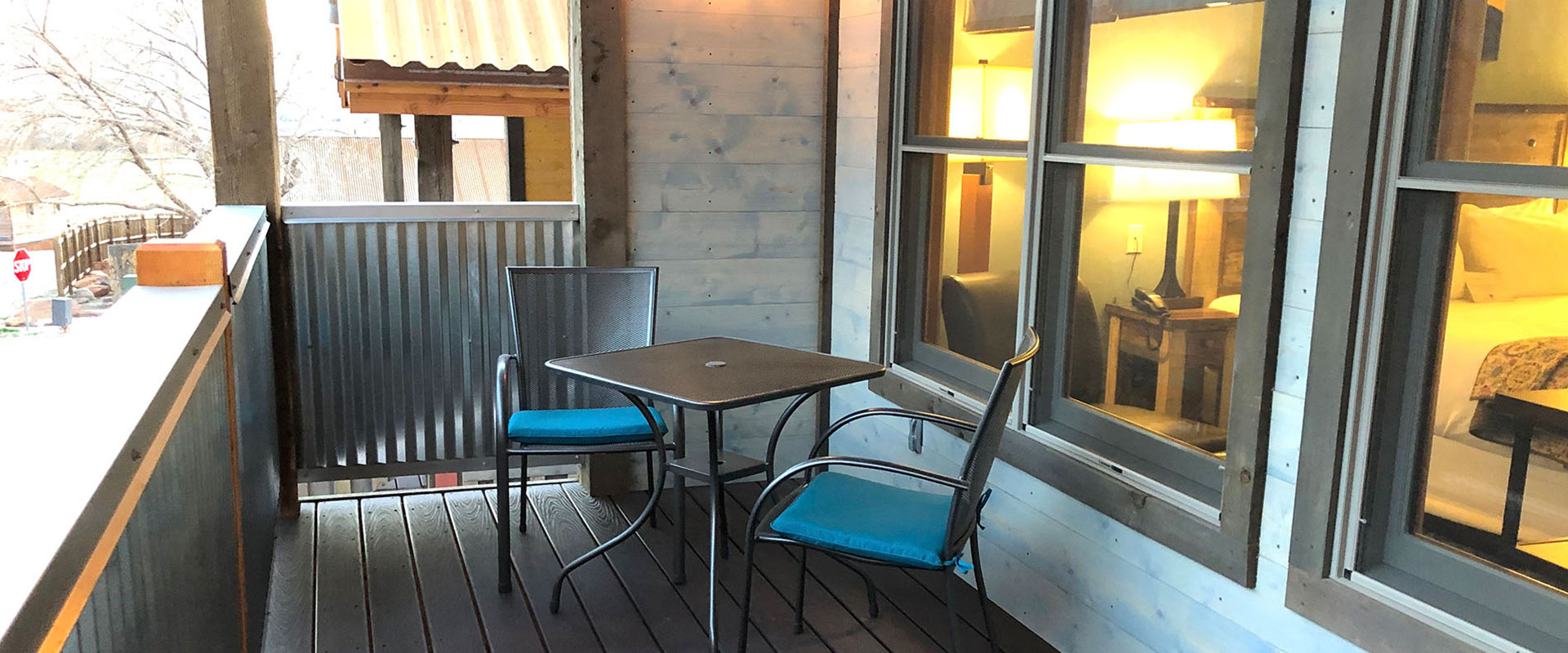 A fully equipped eat-in kitchen in Unit #21 at Moab Springs Ranch has a gas stove, stainless steel appliances, and a wrap around breakfast island with two leather stools.