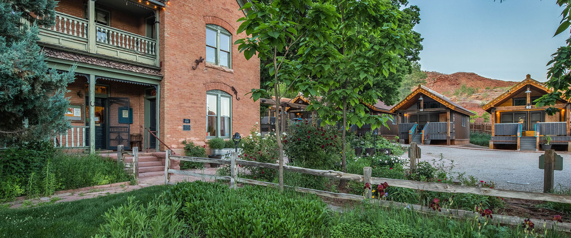 Exterior view of a townhouse unit at Moab Spring Ranch with a series of casement and sash windows and a wood built awning providing a cover over the garage.
