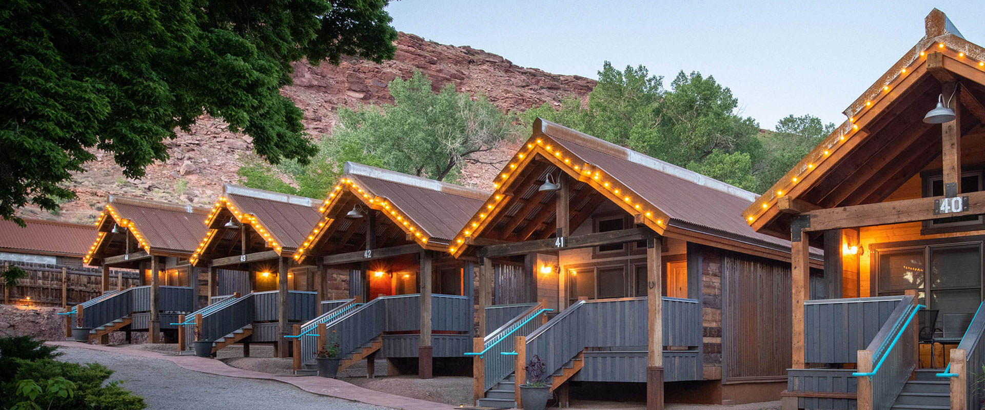 A view of two storey townhomes with closed garages and surrounding trees bearing yellow leaves on a cloudy day at Moab Springs Ranch in Utah.