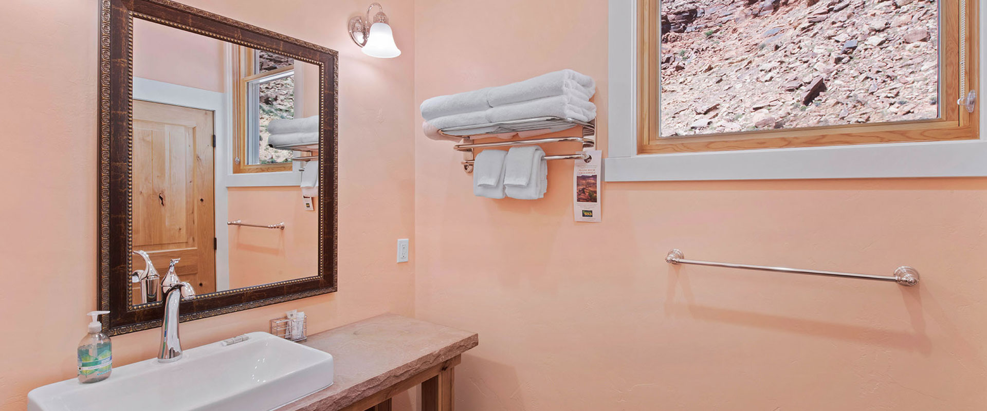 Aerial viewpoint of the eating and living spaces of Unit #19 at Moab Springs Ranch with a large red leather couch placed next to the wrap around breakfast island.