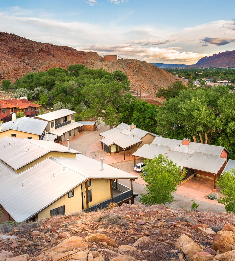 Partial aerial view of the natural brown wood and yellow painted townhouses on the property of Moab Springs Ranch.